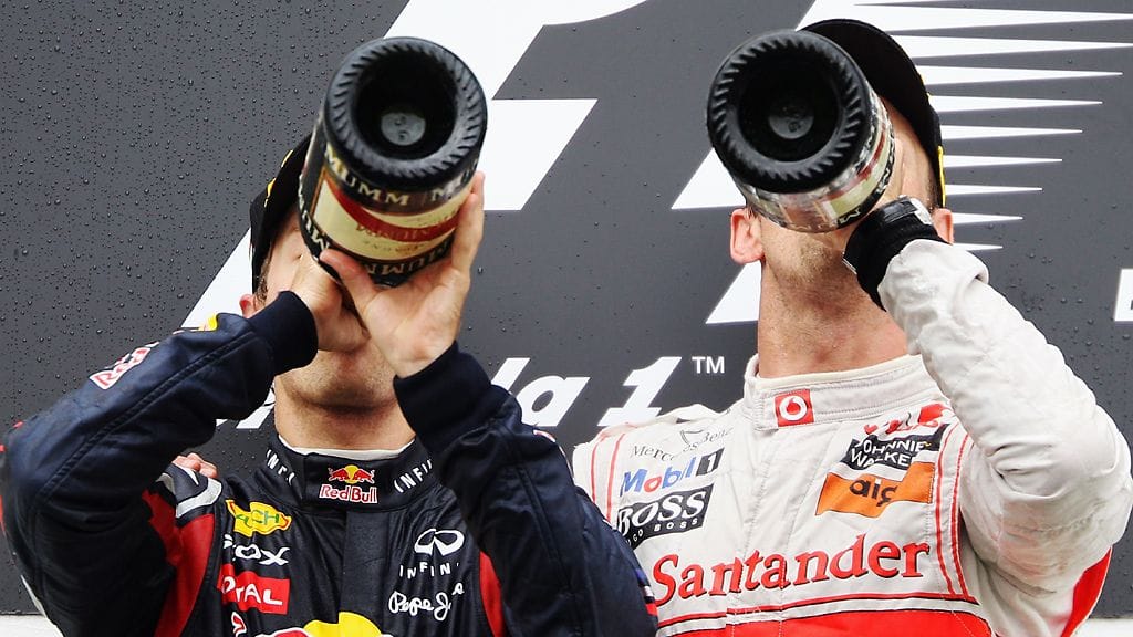 Vettel ja Button kaatavat kurkkuunsa samppanjaa.