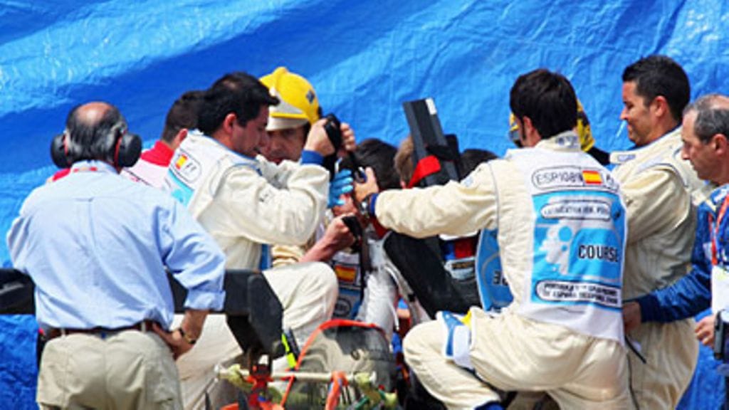 Heikki Kovalainen nostetaan autosta, kuva: Mark Thompson/Getty Images)