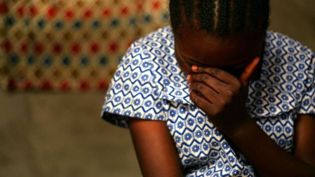 Kongolainen nainen peittää kasvonsa kuvaillessaan kokemaansa raiskausta terveystyöntekijälle. Kuva on vuodelta 2006.