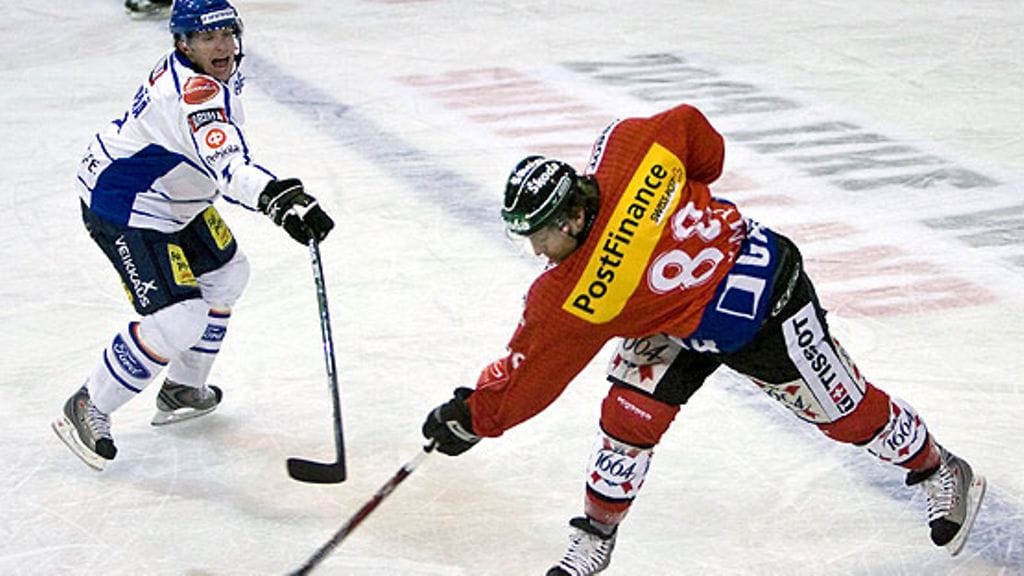 Mikko Mäenpää kurottaa Kevin Romyn laukaukseen. Kuva: Ennio Leanza/EPA.