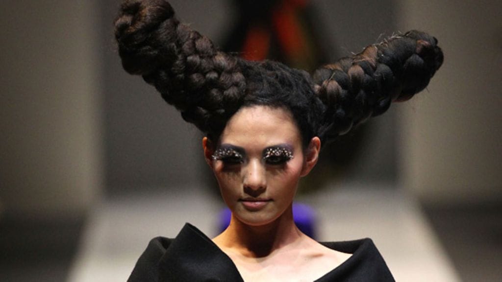 Hiustaiteilijat esittelevät luomuksiaan muotinäytöksissä.