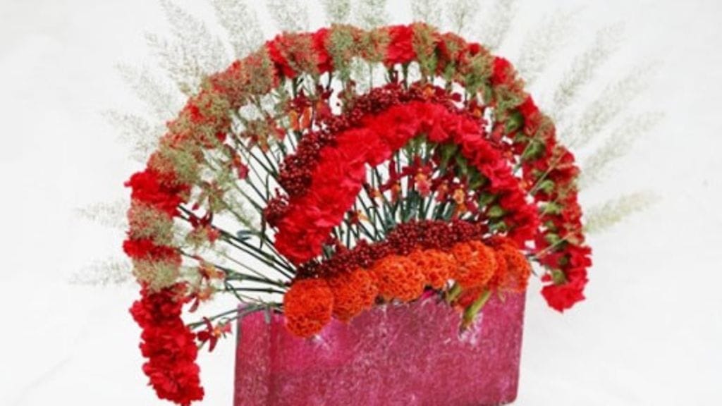 Jouluasetelma neilikoista, heinistä, kukonharjasta, rosepippurista ja Burrageara Stefan  Isler 'Lava Flow' -orkideoita. Kuva: Jouni Seppänen