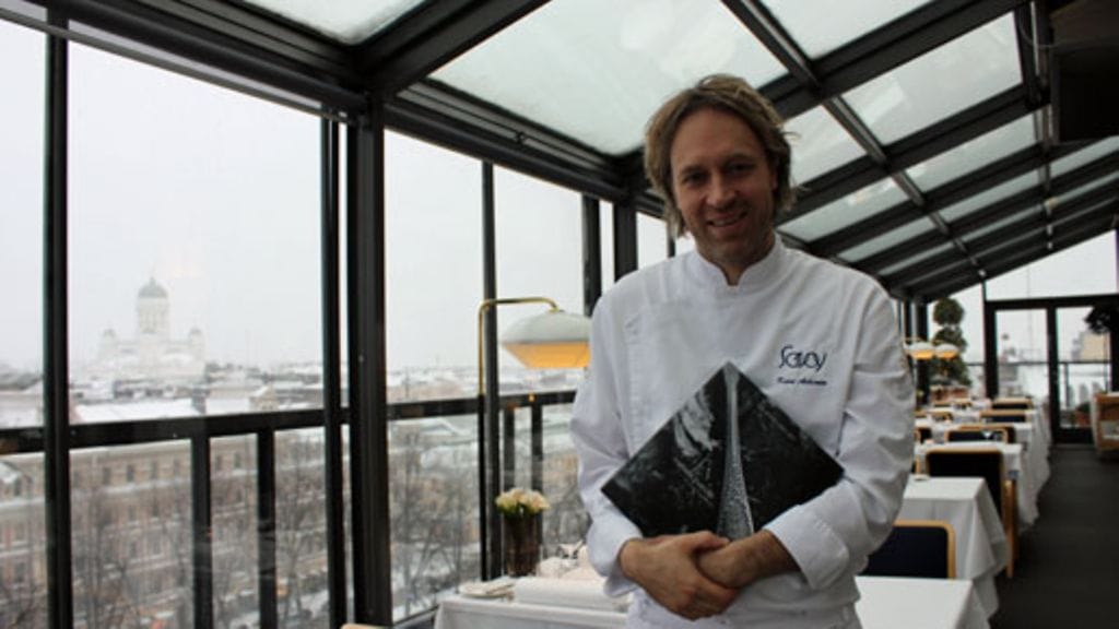 Kari Aihinen Helsigin kattojen yllä ravintola Savoyssa tuore Savoy-kirja kädessään 29.11.2012