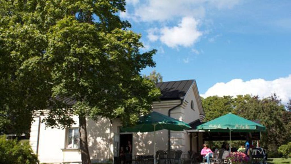 90-vuotias entinen saunarakennus palvelee ruusutarhan kahvittelijoita.