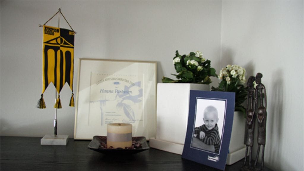 Koriste-esineitä Hannalla ei paljon ole, kaikki ovat lipaston päällä. Vuoden lyseolainen -tunnustusviiri, Vuoden ravitsemusterapeutti -palkinto ja kummipojan kuva. Kuva: MTV3.