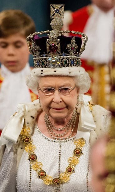 Queen Elizabeth II, wearing the Imperial State Crown, proceeds through the Royal Gallery in the Palace of Westminsterduring the State Opening of Parliament on May 9, 2012 in London, England.
