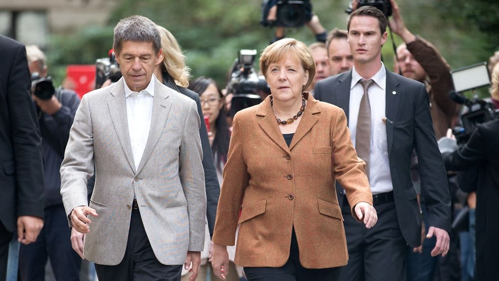 Liittokansleri Angela Merkel puolisonsa Joachim Sauerin kanssa äänestypaikalla Berliinissä 22.9.3013.