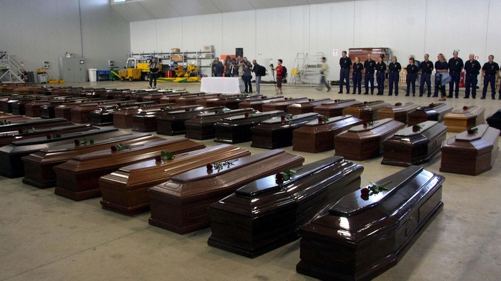 Pakolaisveneturman uhrien arkkuja Lampedusan lentokentällä 5. lokakuuta 2013.