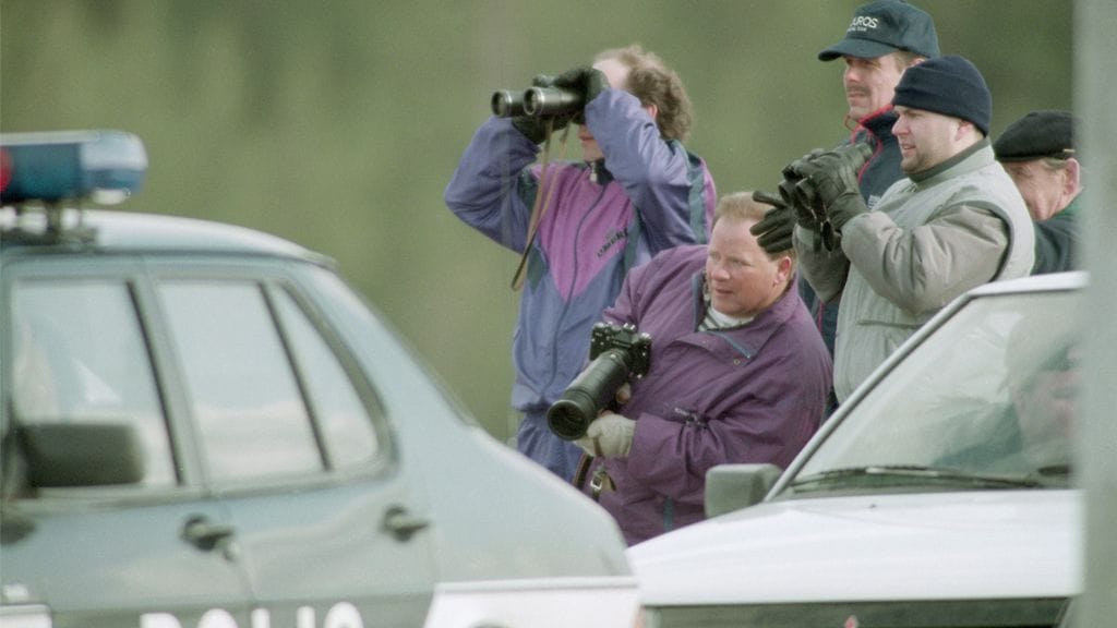 Poliisi piirittää Mika Murasen oletettua piilopaikkaa Karhulassa 19.4.1994. Ihmiset seuraavat tapahtumia. Kymen ilmatorjuntarykmentissä palvellut varusmies Muranen tappoi jalkajousella kolme ihmistä Karhulassa (18. ja 19. huhtikuuta 1994.) ja ammuskeli varuskunnasta varastamallaan rynnäkkökiväärillä ihmisiä kohti