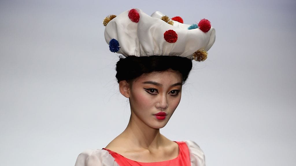 LIANVIS Lian Huiqing toi lavalle modernin samurain. Vihreä paita laskeutuu kevyesti, ja läpinäkyvyys vain korostaa keveää vaikutelmaa. Pussittavat housut sopivat ilmavaan kokonaisuuteen.