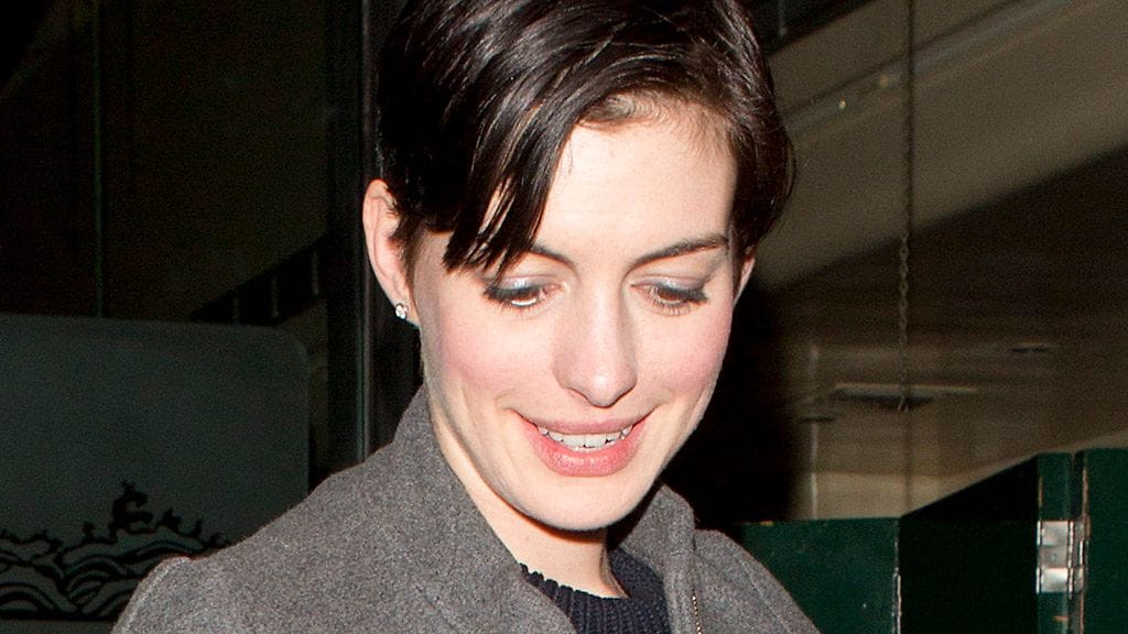 Anne Hathaway yhdisti ylipitkän hameen pitkään, harmaaseen takkiin.