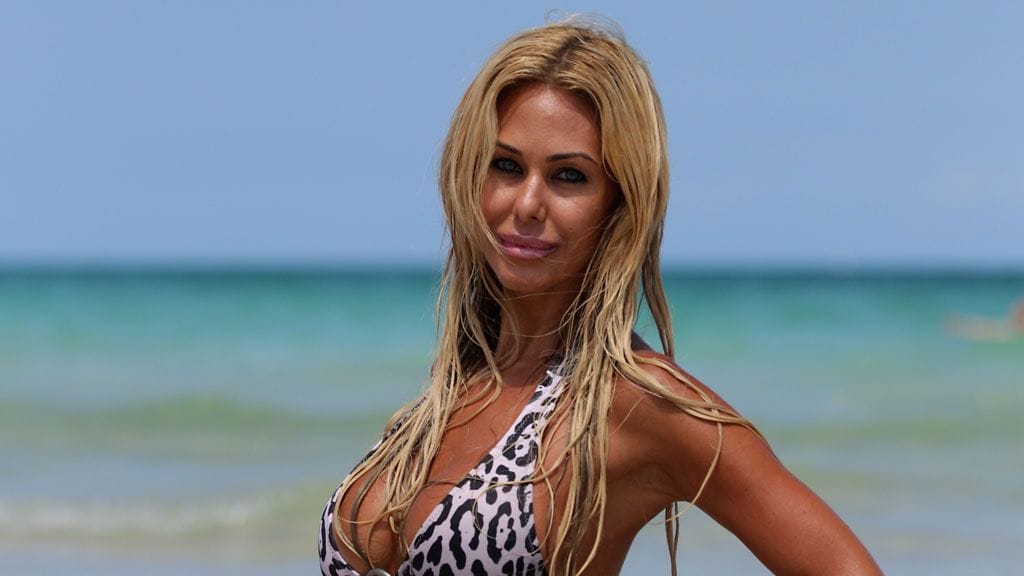 Näyttelijä Shauna Sand esittelee uhkeata rintavarustustaan monikinissa.