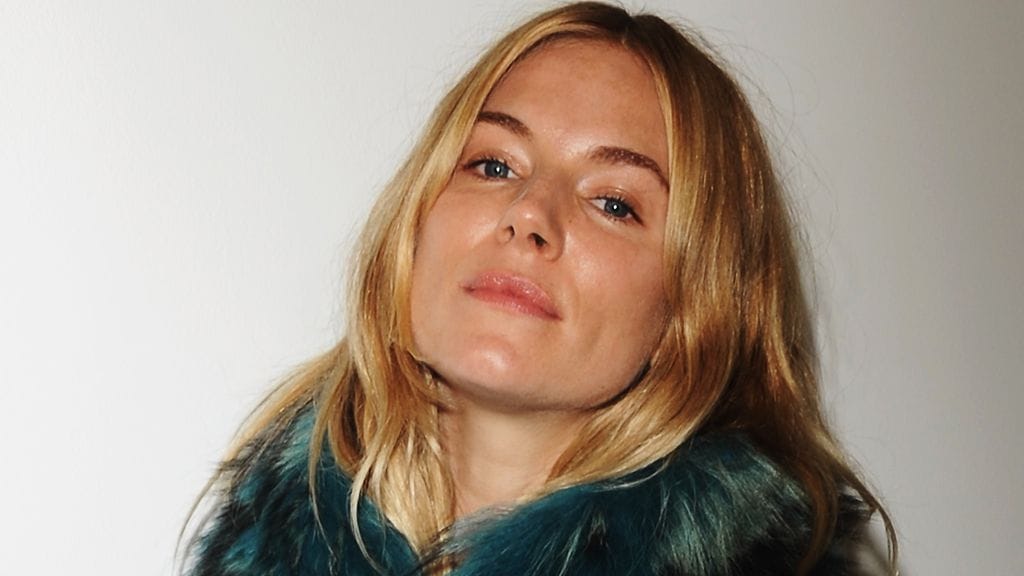 Sienna Miller puki näytökseen ylleen sinisävyisen paidan ja turkiskaulaurin. Jalkaan näyttelijätär oli valinnut hiukan miestenkenkiä muistuttavat matalat jalkineet.