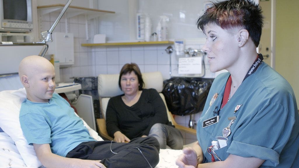 Sairaanhoitaja Sirkku Rajala juttelee pienen potilaansa kanssa.