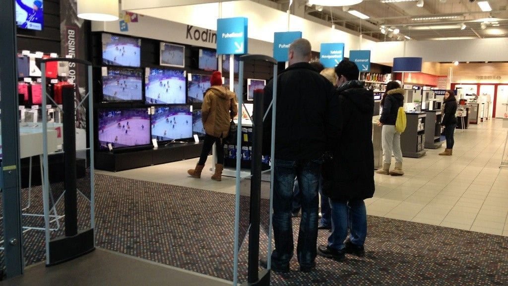 Ihmisiä Jumbon Mustan Pörssin myymälässä lätkää seuraamassa.