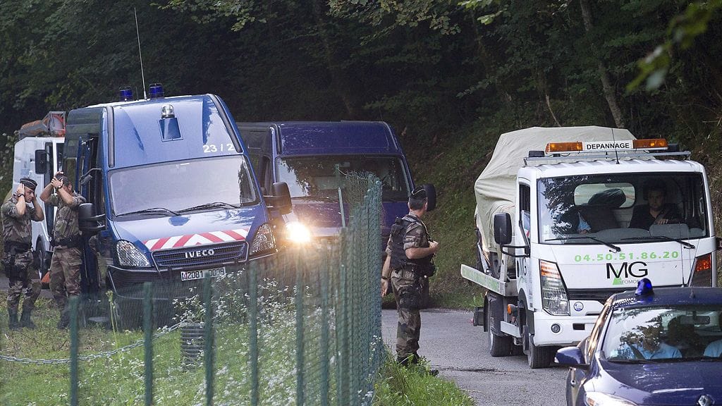 Alpeilla joukkosurman uhreiksi joutuneiden autoa kuljetetaan pois.