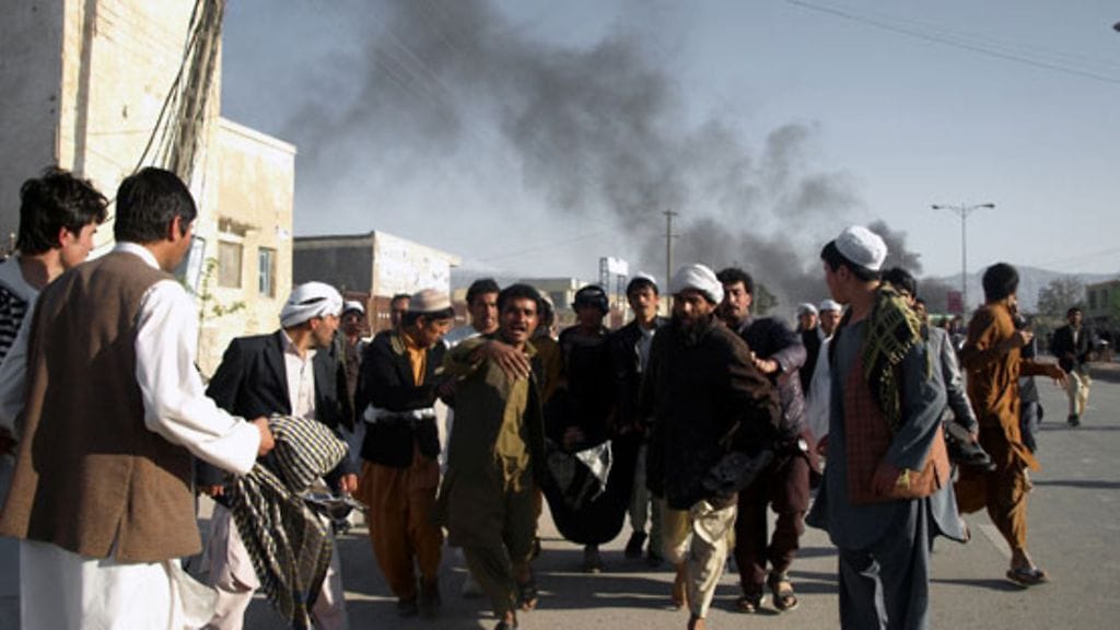 Loukkaantunutta miestä kannetaan Mazar-i-Sharifissa Pohjois-Afganistanissa 1.4.2011.