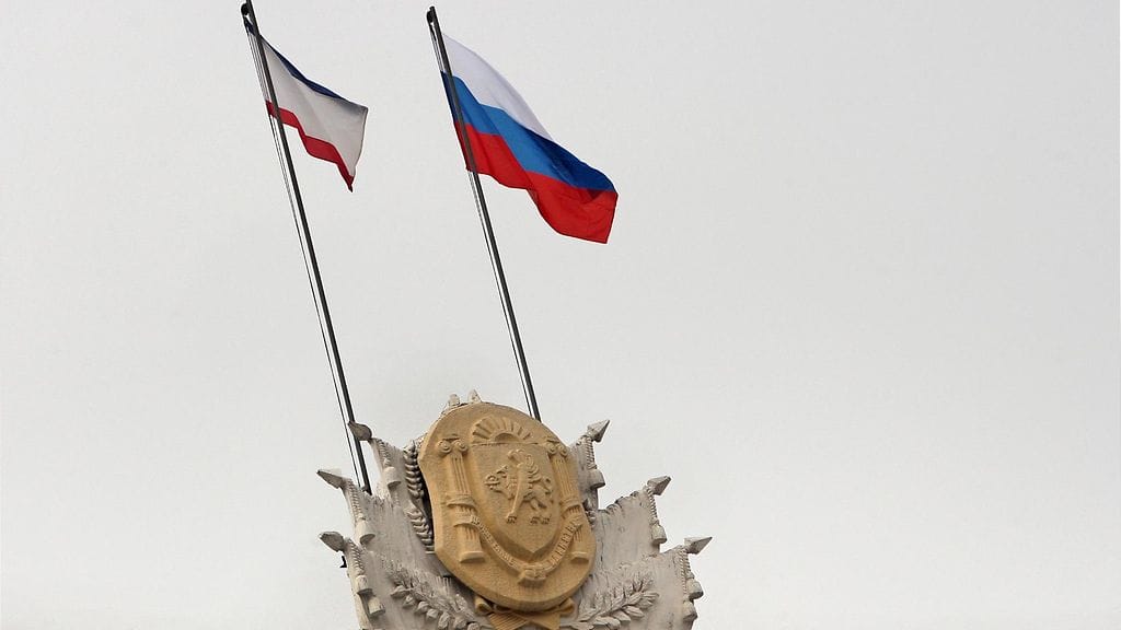 Krimin ja Venäjän liput liehuvat vierekkäin hallintorakennuksen katolla Simferopolissa 1.3.2014.