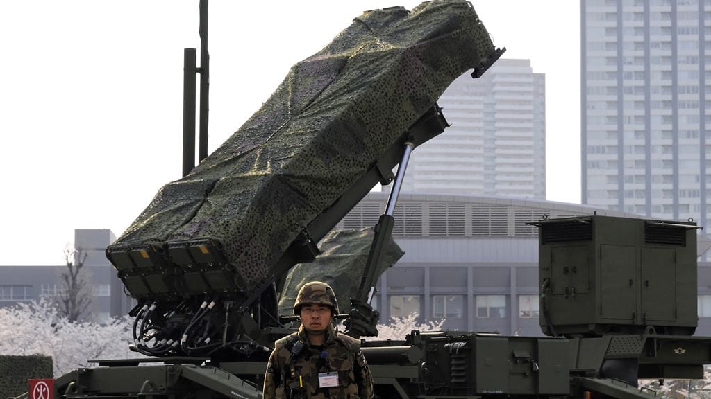 Japanilaissotilas Patriot-ohjuksen edessä.