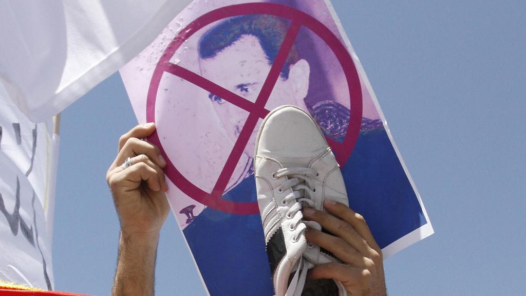 Syyrialainen mielenosoittaja pitää kädessään presidentti Bashar al-Assadia vastustavaa kuvaa. Mielenosoitukset ovat jatkuneet jo viikkoja.