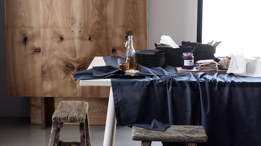 Puupinnat lämmittävät tummaa sisustusta. Kuva H&M