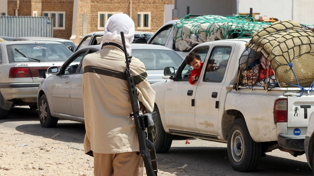 Libyan kapinallinen vartioimassa rajanylittäjiä Tunisian ja Libyan rajalla.