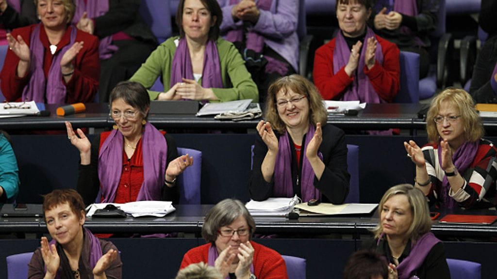 Members of the Left Party faction applaud during a meeting of the German Federal Parliament Bundestag in Berlin, Germany, Thursday, March 8, 2012. The Left Party sent only women wearing a purple scarves to the debate about women's equality in Germany on International Women's Day. (AP Photo/Michael Sohn) Lehtikuva