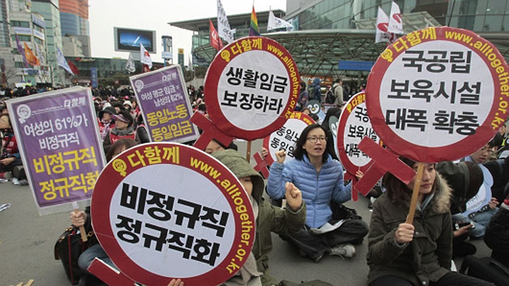 South Korean female workers shout slogans during a rally to mark International Women's Day in Seoul, South Korea, Thursday, March 8, 2012. The letters read "Preserve a living wage and hire more temporary employees." (AP Photo
