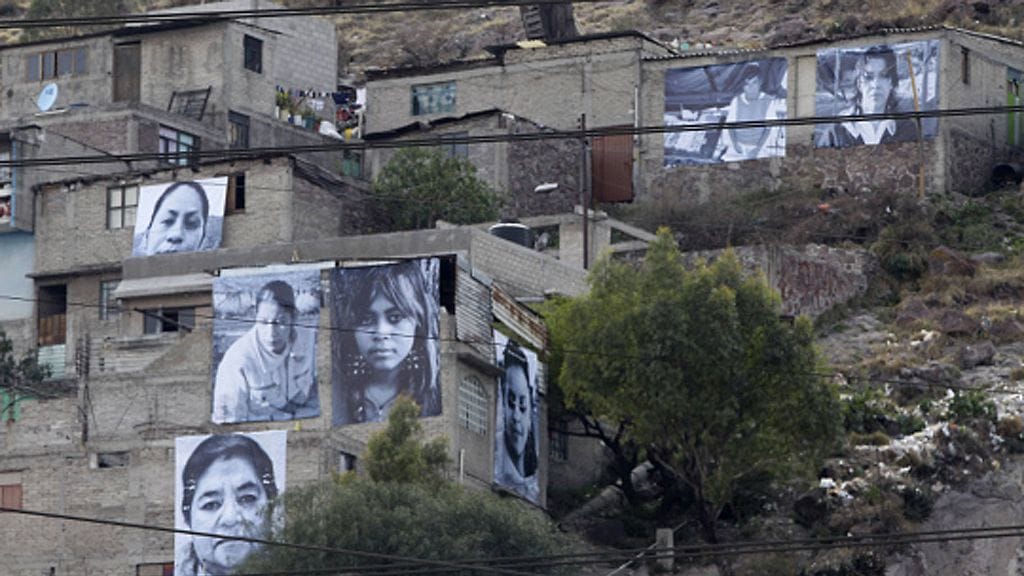 Pictures of victims of violence are hung on the facades and walls of houses in the neighbourhood of Cerro Gordo in Ecatepec, outside Mexico City March 7, 2012. The Murrieta Foundation opened an exhibition called "Giving face to the victims in Ecatepec" with 15 giant photographs placed in different facades and walls of the houses as part a campaign against violence (rape of women, kidnappings, murders and robberies) in Ecatepec. LEHTIKUVA / REUTERS/Henry Romero (MEXICO - Tags: CRIME LAW CIVIL UNREST SOCIETY TPX IMAGES OF THE DAY)