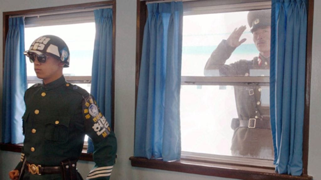 Pohjois- ja Etelä Korean väliin jäävä aselepolinja, Pan Mun Jom, on viimeinen kylmän sodan linnake maailmassa. Kuvassa Etelä -Korean sotilas. Ikkunasta kurkkii uteliaana Pohjois -Korean upseeri. Kuva:Lehtikuva