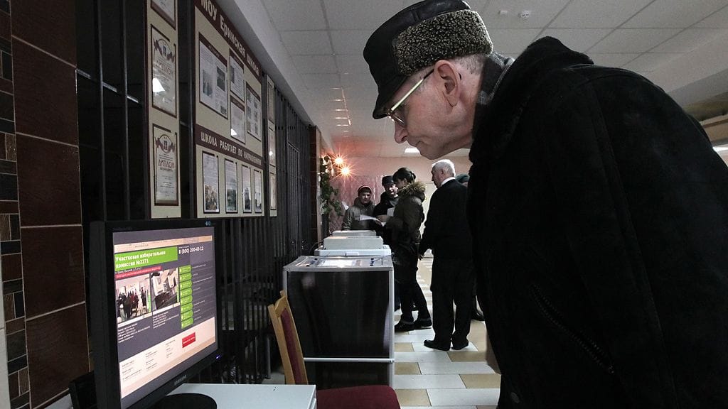 Mies katselee web-kameroiden välittämää kuvaa äänestyspaikoista Yerinon kylässä Moskovan lähellä.