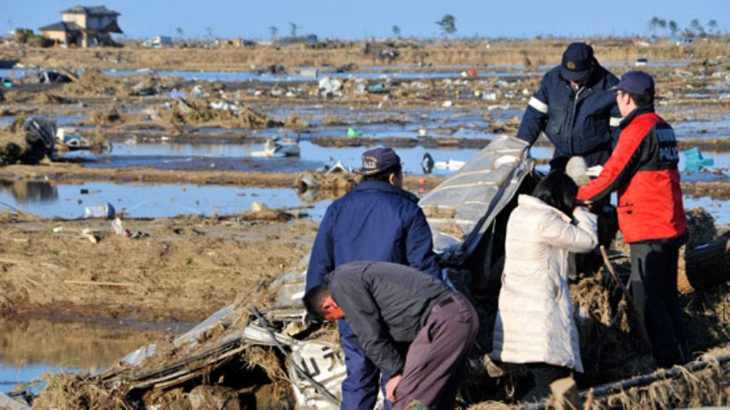 Perhe on saanut juuri kuulla suru-uutisen poliisilta: Heidän tyttärensä on kuollut tsunamin murskaamaan autoon. Kuva: EPA