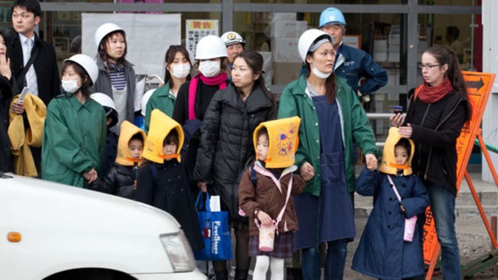 Pelko uusista järistyksistä näkyy myös kaduilla. Kuvassa esikoululaisia ja näiden ohjaajia suojapäähineissään Tokiossa 15. maaliskuuta 2011. (EPA)