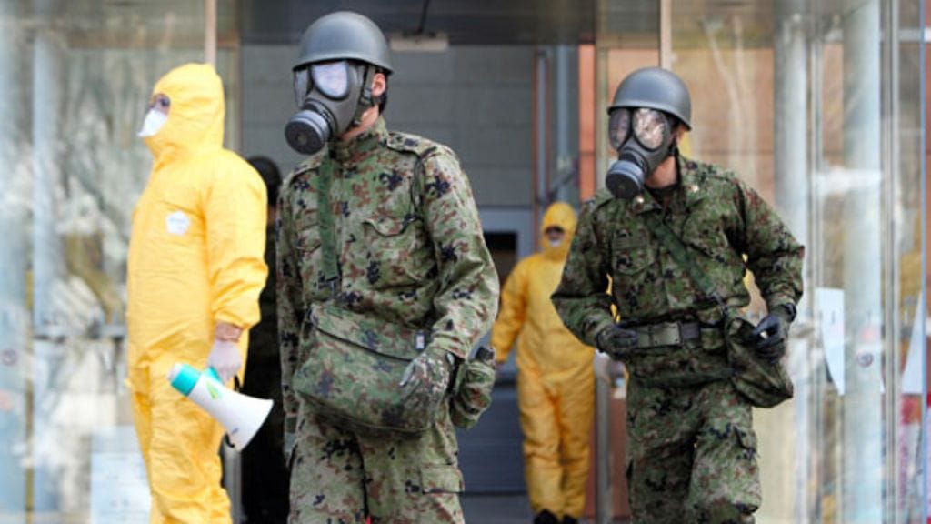 Japanin asevoimien sotilailla on yllään suojanaamarit radioaktiivisen säteilyn varalta Otaman kylässä Fukushiman prefektuurissa 13.3.2011.