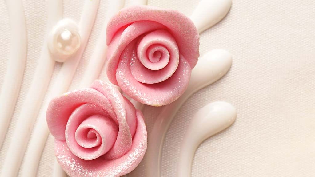 Kieputa marsipaanista tehtyjä terälehtiä toistensa ympärillä ja taivuta terälehtiä hiukan alaspäin tehdessäsi marsipaaniruusua.