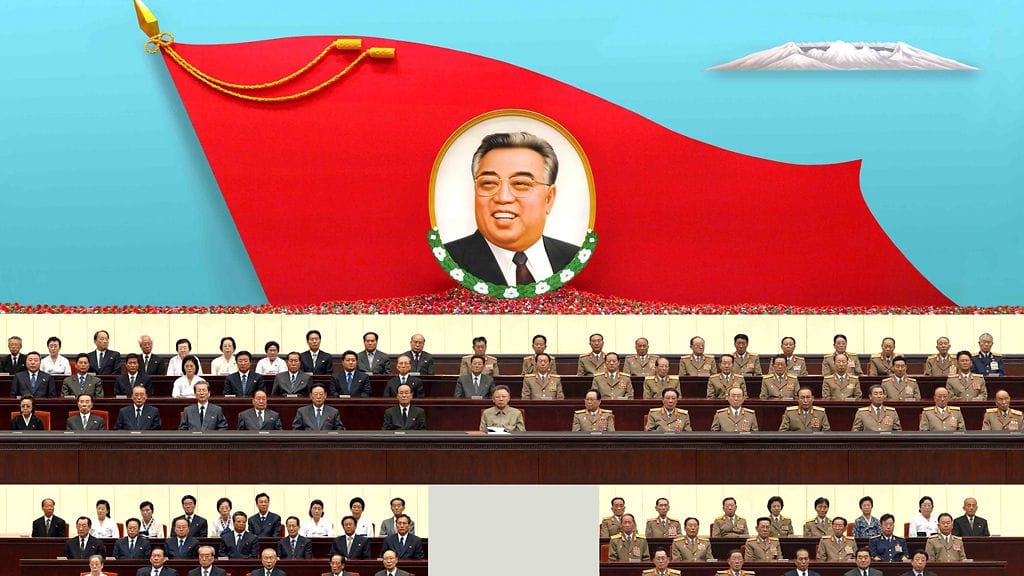 Pohjois-Korean juche-aate perustuu maan ikuisen presidentin Kim Il-Sungin (lipussa) opetuksiin.