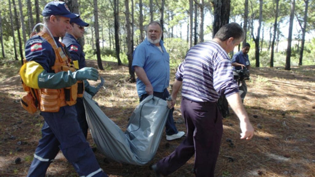 Poliisi kantaa suomalaisen Toni Hakalan surmaaman naisen ruumista kätköpaikalta 9. toukokuuta 2008. (AP)