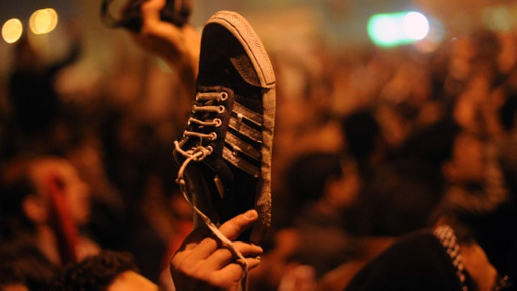 Ihmiset osoittivat mieltään torilla nostamalla kenkänsä kohti taivasta presidentti Hosni Mubarakin puheen jälkeen. EPA