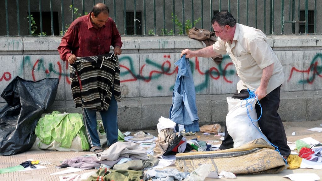 Ihmiset keräsivät tänään mielenosoittajien jälkeensä jättämiä tavaroita Kairossa.