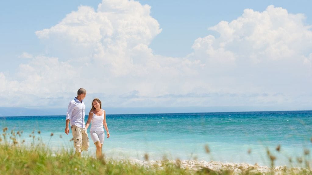 Pariskunta kävelee rannalla