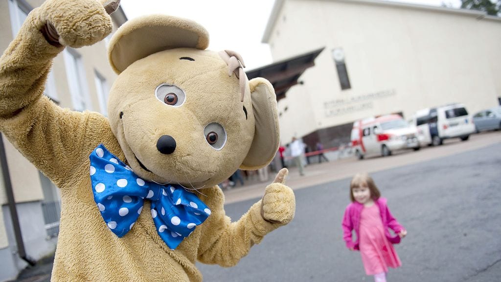Emilia Janke seuraa taustalla Hilarius-hiirtä, joka saapui evakuointikeskukseen ihmisten iloksi.