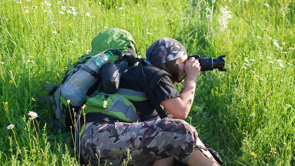 Luontokuvaaja kuvaa pellolla