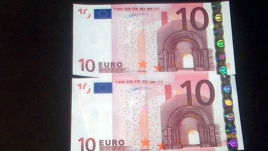 Oikea ja mahdollisesti väärä kymmenen euron seteli. Alemman setelin hologrammi on reilut kaksi millimetriä lähemänä reunaa kuin ylemmän setelin. Setelit eivät liity Portugalista löytyneisiinväärennöksiin.