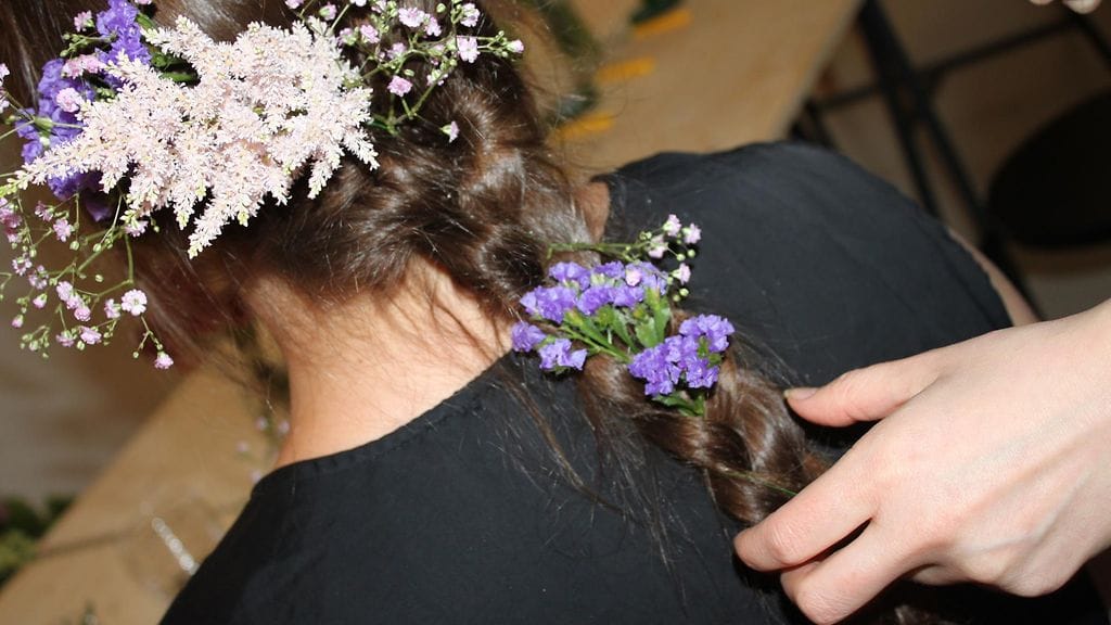 Suunnittelija Laura Väinölä koristelee letin kukkasin.