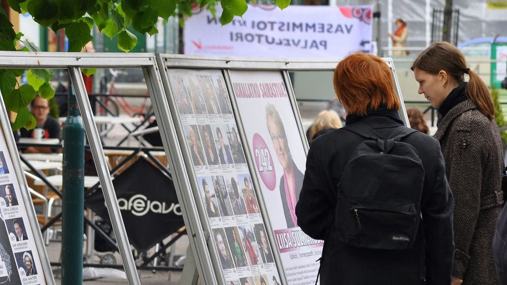 Kaksi naista tutkii vaalimainoksia Helsingissä keväällä 2009.