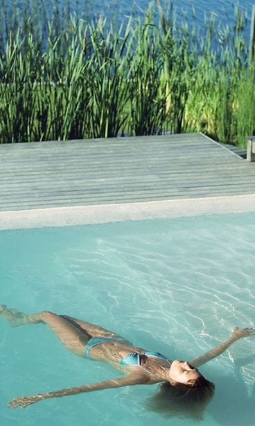 Nainen kelluu uima-altaassa