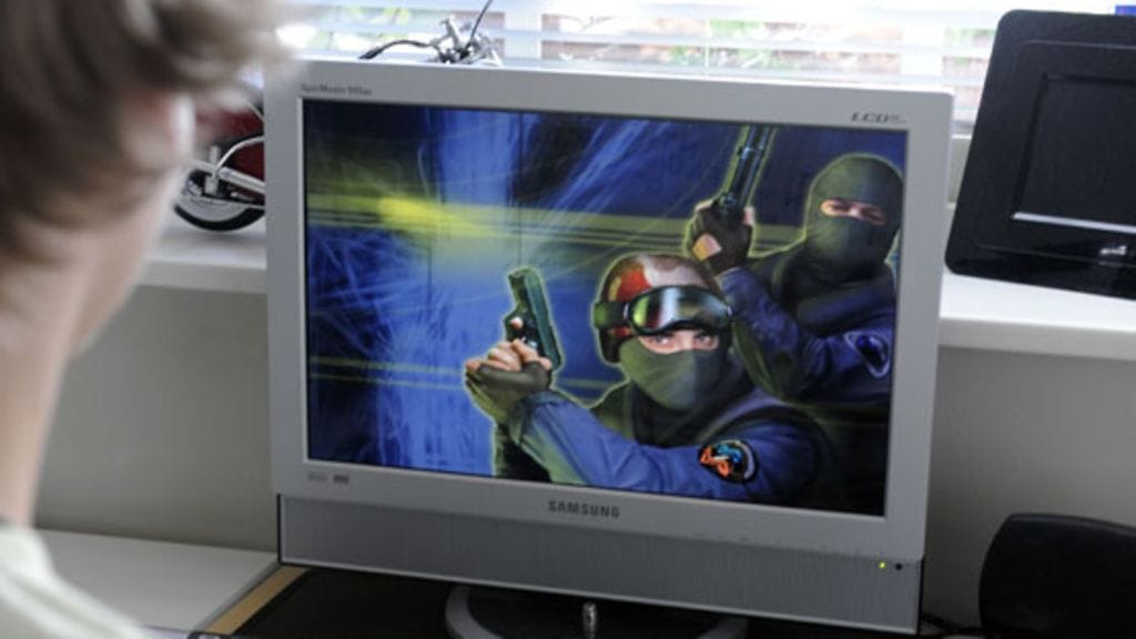 Kuvituskuvaa. Nuori mies pelaa tietokonepeliä kotonaan.