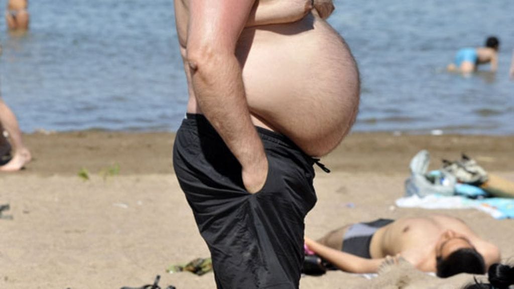 Isovatsainen mies rannalla. (Lehtikuva)