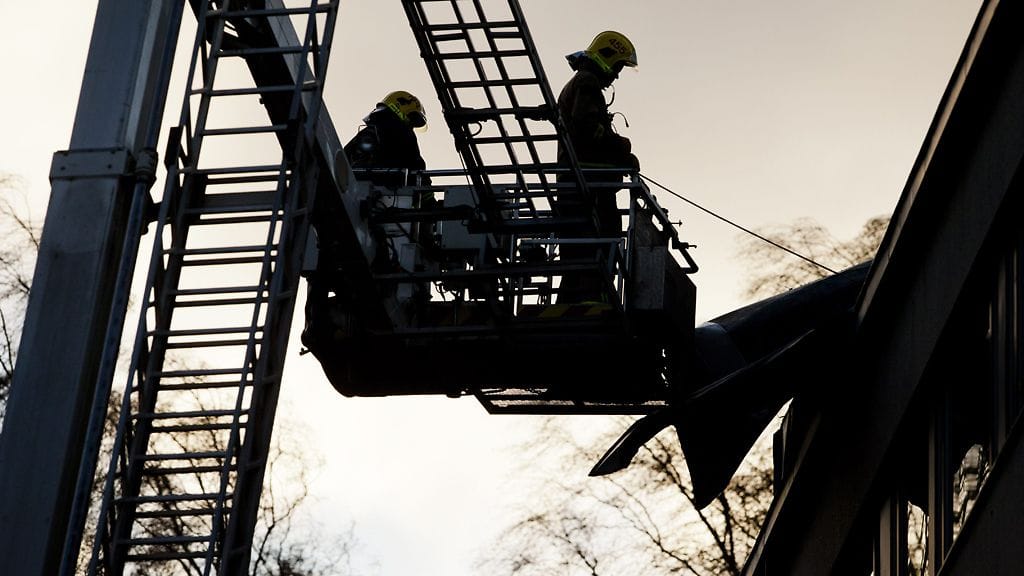 Palomiehet korjaavat hajonnutta kattoa Lauttasaaressa Helsingissä, 26. joulukuuta 2011.