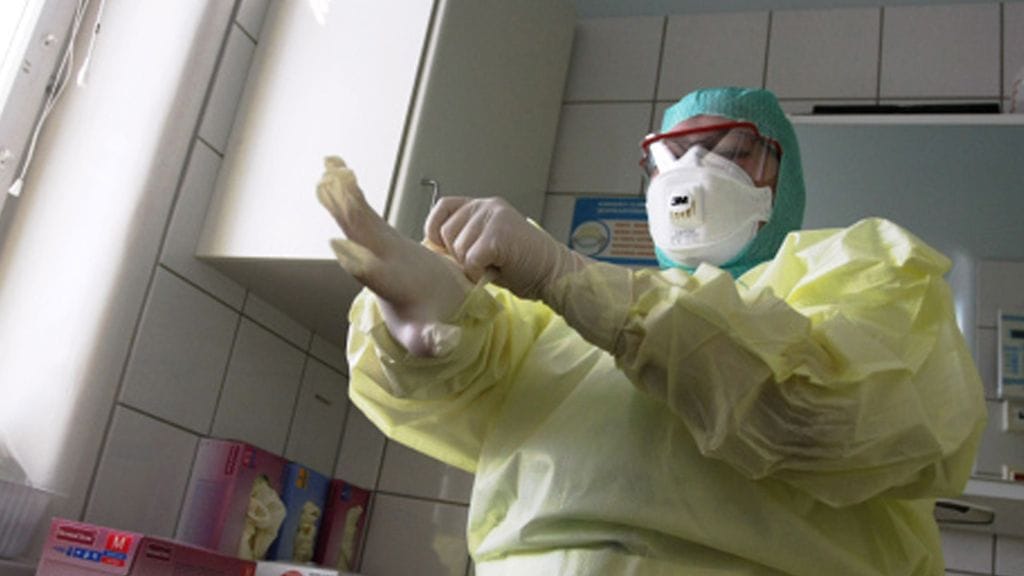 Suojapukuun pukeutunut hoitaja infektio-osastolla Auroran sairaalassa Helsingissä 27. huhtikuuta 2009.